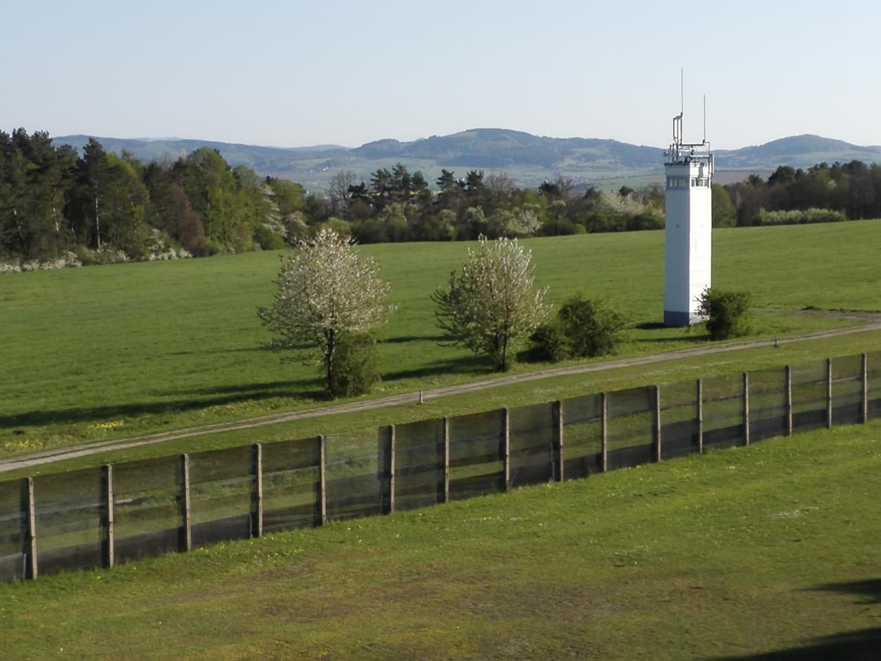 Wachturm der DDR-Grenztruppen hinter dem Grenzzaun